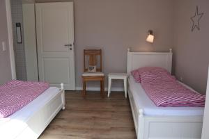 zwei Betten in einem Zimmer mit einer Tür in der Unterkunft Bungalow Gartenzauber in Grube