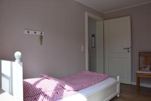 Schlafzimmer mit einem Bett mit rosa und weißer Bettwäsche in der Unterkunft Bungalow Gartenzauber in Grube + 4 Fotos