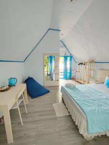 a bedroom with a bed and a desk in a room at Tria Maria Cottage in Ngurblut