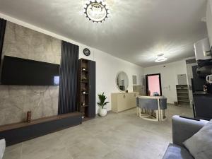 un salon avec une télévision et une table dans l'établissement Celia new capital 2 bedrooms, à Madīnat al Amal