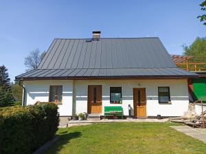 a small white house with a gray roof at Chalupa Emma in Tanvald