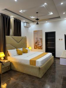 ポートハーコートにあるCZ Hotelのベッドルーム1室(大型ベッド1台、黄色い枕付)