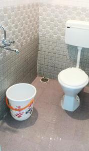 a bathroom with a toilet and a bucket at package stay,transport,sightseeing in Puttaparthi