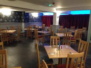 a dining room with wooden tables and chairs at The Wheatsheaf in Crick