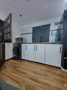 a kitchen with white cabinets and a sink at The Cozy Cabin in Pretoria