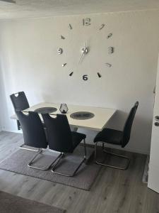 a table and chairs with a clock on the wall at Ferienwohnung Dadaa in Albstadt