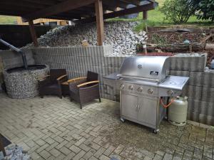 a grill in a backyard with some chairs and a table at Monteurwohnung in Wilnsdorf