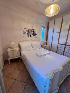 ein Schlafzimmer mit einem großen Bett und zwei Tischen in der Unterkunft Olive Tree House I in Dhermatiánika