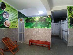 a room with a bench and a golf course mural at Hostal El Eucalipto Medicinal in Tingo María