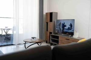 a living room with a tv and a coffee table at Tirana Hideaways, Free Parking & Breathtaking View in Tirana