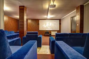 a lecture room with blue chairs and a projection screen at Апартаменти Форест Нук - ФАЗА 1 in Pamporovo