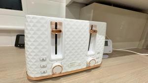 a white appliance sitting on the floor in a room at Cozy 5-Bed Caldecott Stays-Sleep 6 in Manchester