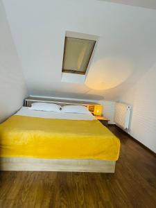 una camera da letto con un letto con una coperta gialla di Iza Bella a Braşov