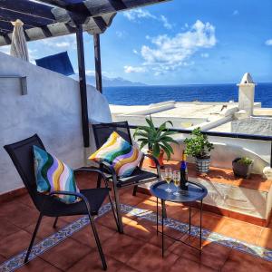 a patio with chairs and a table with a view of the ocean at Vista Mar Sardina in Gáldar