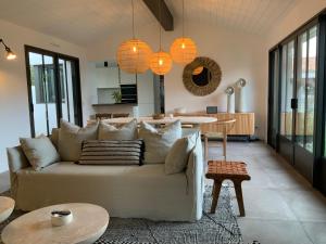 a living room with a couch and a table at Les Villas du Bois in Le Bois-Plage-en-Ré