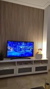 telewizor z płaskim ekranem siedzący na szafce w obiekcie CASARES appart 2 ch dans parc tropical avec vue sur mer, montagne et piscine w mieście Casares