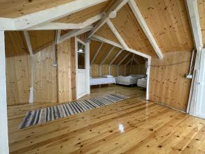 Una habitación abuhardillada con paredes y suelos de madera. en Meti guest house wooden room, en Krujë