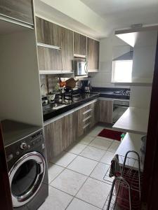 eine Küche mit Waschmaschine und Herd oberen Backofen in der Unterkunft Condomínio Marina Clube in São Pedro da Aldeia + 31 Fotos