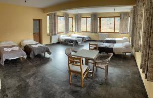 een kamer met bedden en een tafel en stoelen bij Bujtina Ziçi in Theth +54 foto's