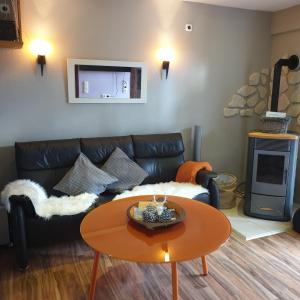 a living room with a leather couch and a table at Feha ehemaliger Stall in Langelsheim