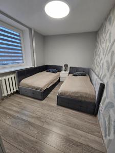 a bedroom with two beds and a window at 2-bedrooms apartment in city center Šiauliai in Šiauliai