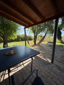 a picnic table in a pavilion with a hammock at Los Huesos 2 in Chascomús