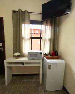 Uma TV ou centro de entretenimento em Pousada Kembali Maresias