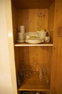 a wooden cabinet with plates and dishes in it at Oide Schreinerei in Steingaden