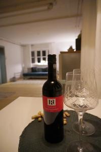 a bottle of wine and a wine glass on a table at Oide Schreinerei in Steingaden