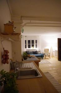 a kitchen and living room with a sink and a couch at Oide Schreinerei in Steingaden +16 photos