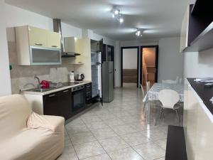 a kitchen and living room with a couch and a table at Comfort Apartment in Assemini
