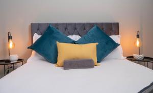 a bedroom with a large bed with blue and yellow pillows at Two At Urban Pulse in Johannesburg