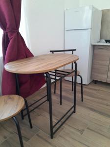 a wooden table and a chair in a kitchen at Alesia C in Ocna-Mureşului