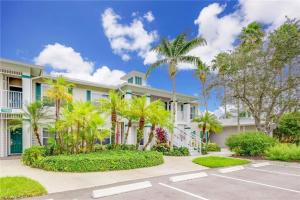 a house with palm trees in front of a parking lot at Spacious 2 bedroom Lely Resort condo Naples FL in Naples