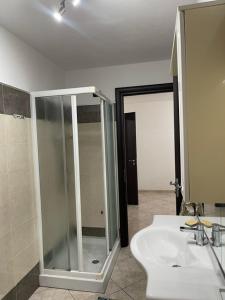 a bathroom with a glass shower and a sink at Comfort Apartment in Assemini