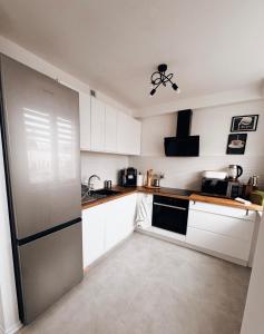 a kitchen with white cabinets and a stainless steel refrigerator at Apartament Świdnik Kosik in Świdnik +21 photos