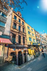 ein Gebäude auf einer Straße mit einer Bank davor in der Unterkunft Zur guten Quelle in Köln