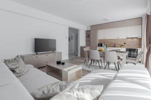 a living room with a white couch and a kitchen at Cream Divine in Oradea