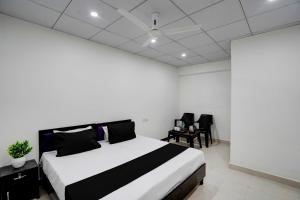 een slaapkamer met een bed en stoelen erin bij SPOT ON Hotel Blu Moon in Noida