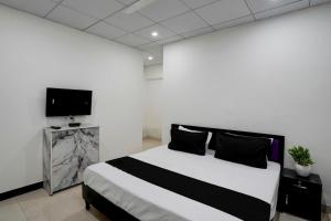 een slaapkamer met een bed en een flatscreen-tv bij SPOT ON Hotel Blu Moon in Noida