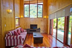 a living room with two couches and a tv at Paradise Holiday Homes Rarotonga in Rarotonga