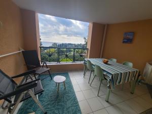 Una habitación con una mesa y sillas y una ventana grande. en Rev'Azur Saint Raphaël, en Saint-Raphaël
