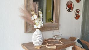 a vase with flowers on a table in front of a mirror at Madina House in Al-Salam +51 photos