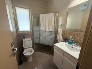 un baño con inodoro y lavabo en הבית של אסף - 3 וילות משפחתיות זהות, en H̱osen