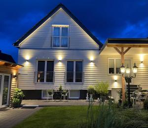 a white house with a table and chairs at night at Ferienwohnung Stamer in Eckernförde