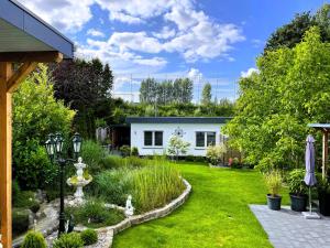 a garden with a white house in the background at Ferienwohnung Stamer in Eckernförde