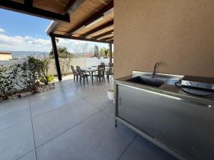 Una cocina con fregadero y una mesa con sillas. en הבית של אסף - 3 וילות משפחתיות זהות, en H̱osen