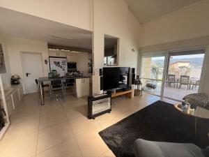 sala de estar con TV y cocina con mesa en הבית של אסף - 3 וילות משפחתיות זהות, en H̱osen 8 fotos más