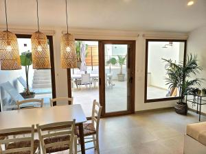 a dining room with a table and chairs and a patio at ElsPeixets Home Mallorca - ArtHouse in Colonia Sant Jordi +14 photos