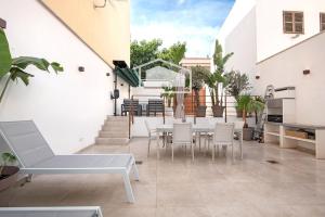 a patio with white furniture and a table and chairs at ElsPeixets Home Mallorca - ArtHouse in Colonia Sant Jordi